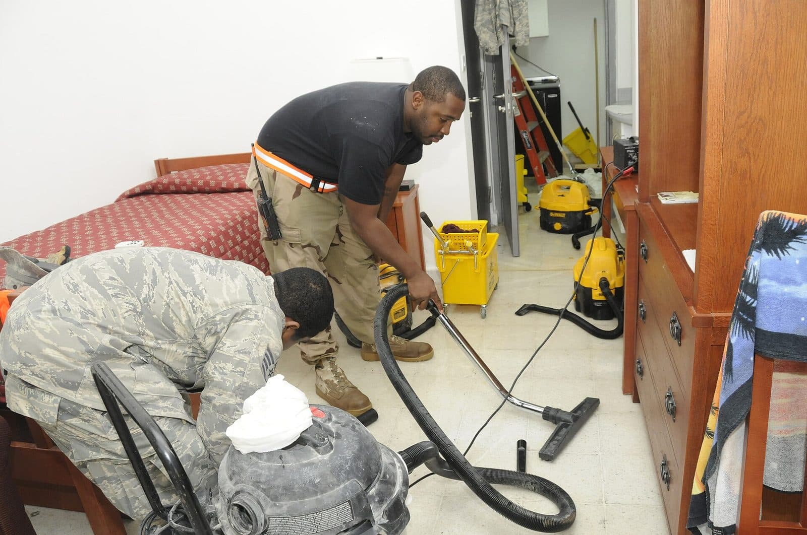 Crew extracting water from a flooded room with wet vacuums